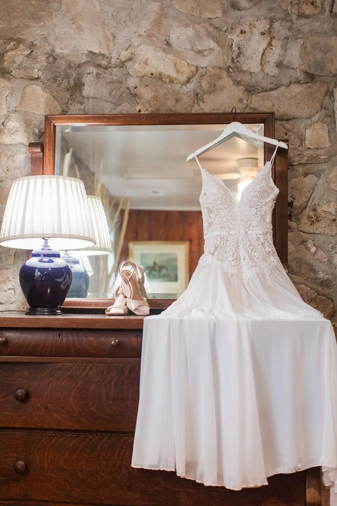 Custom made lace and chiffon wedding dress on a hanger in a bridal atelier
