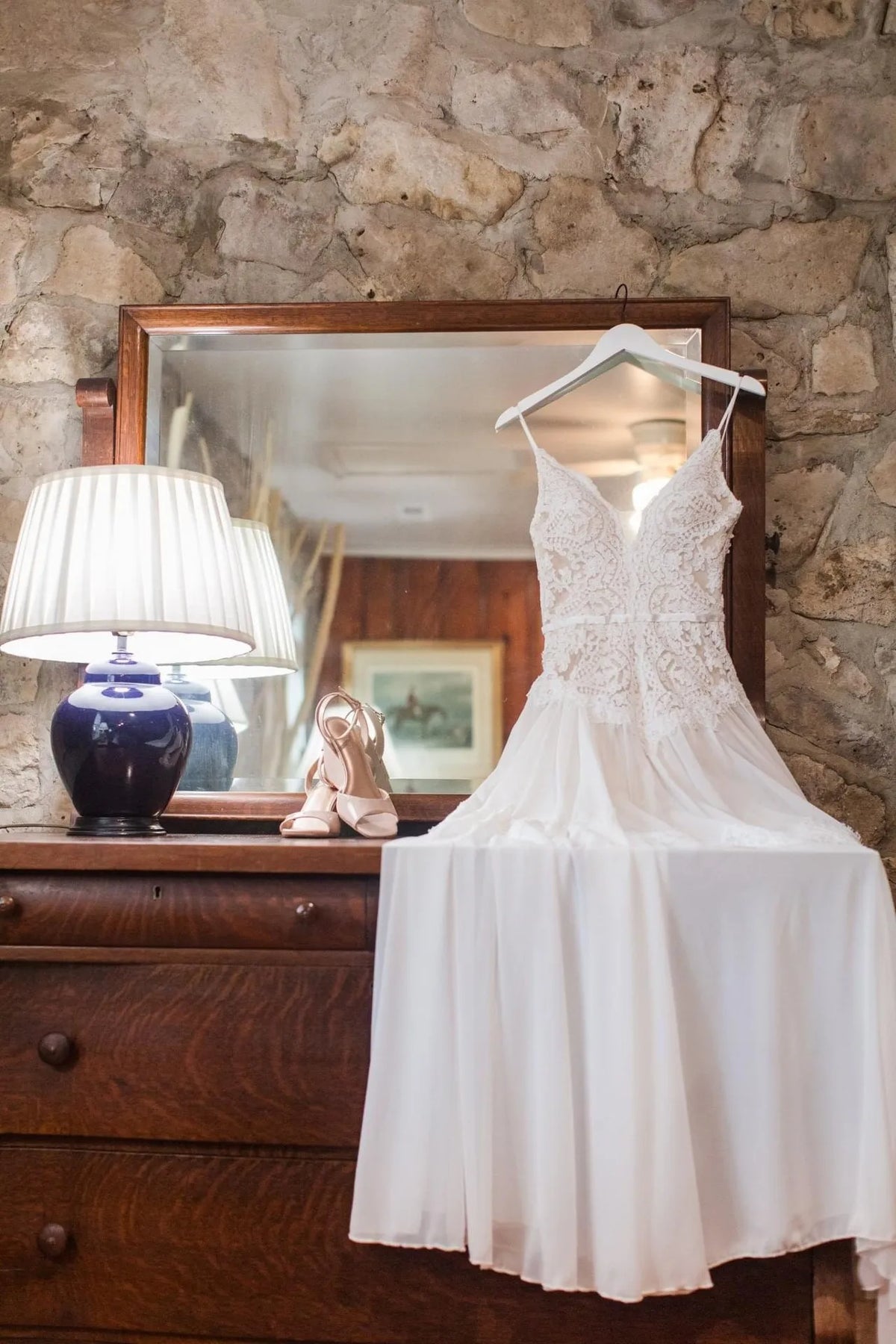 Custom made lace and chiffon wedding dress on a hanger in a bridal atelier