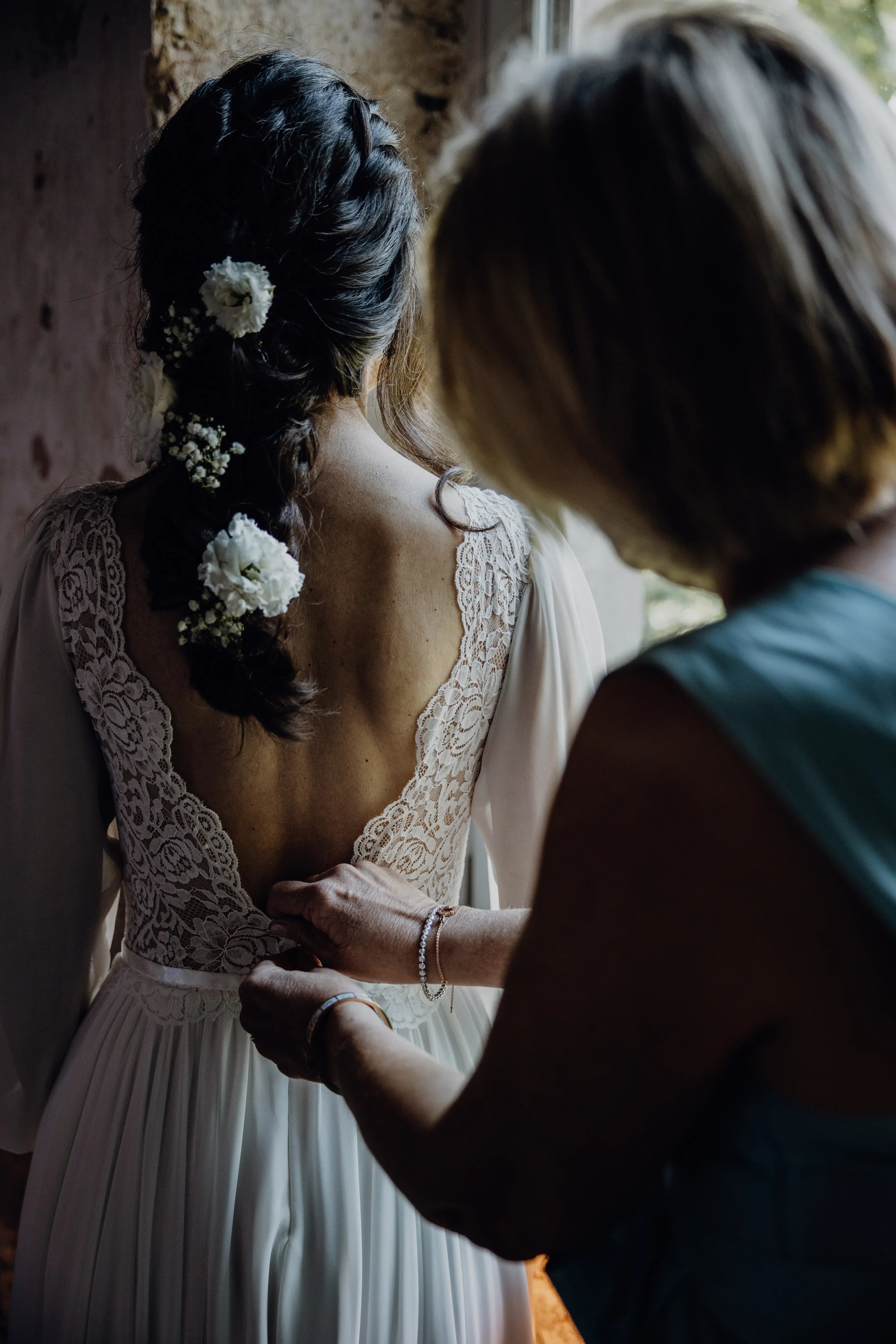 Bride wearing a boho lace wedding dress during bridal getting ready moments before the wedding ceremony.