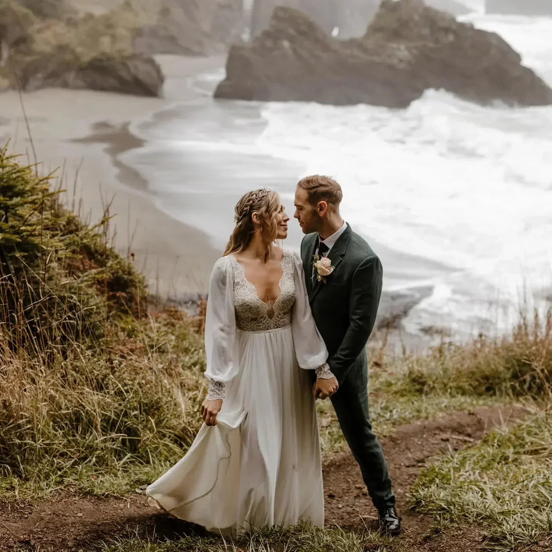 Real bride in a long sleeve sheer boho wedding dress on a coastal cliff, made to measure by Shany Sasson