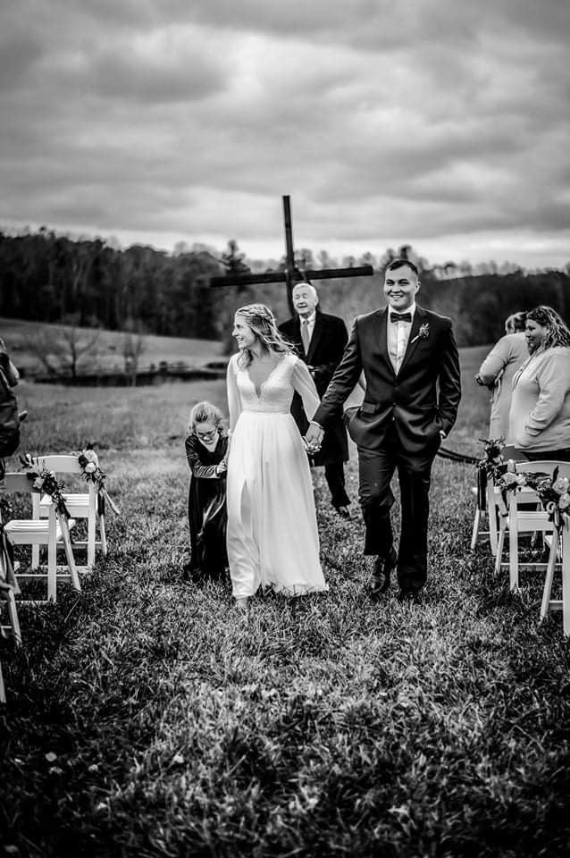 Black and white photo of a bride and groom during an outdoor boho wedding ceremony.