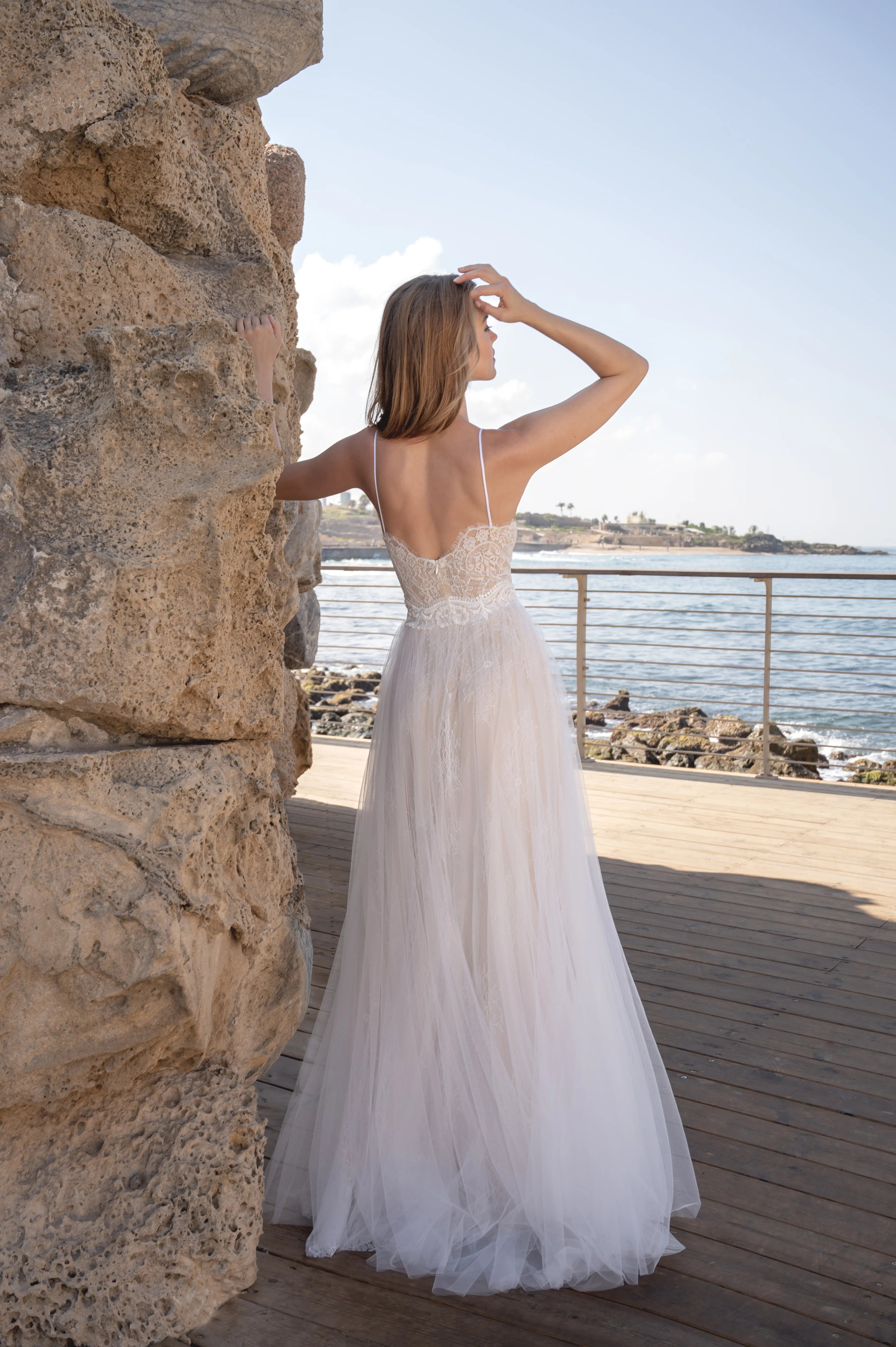 Side view of a boho bridal gown with a soft flowing skirt by the beach
