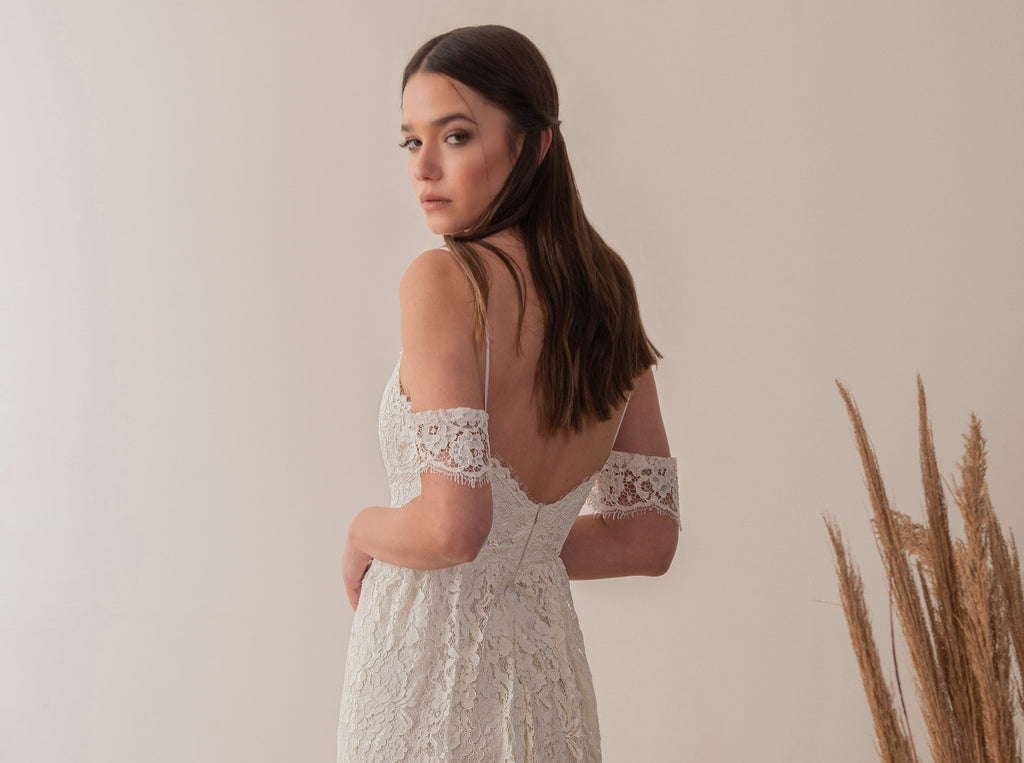 Profile view of a boho lace wedding dress with fitted lace silhouette