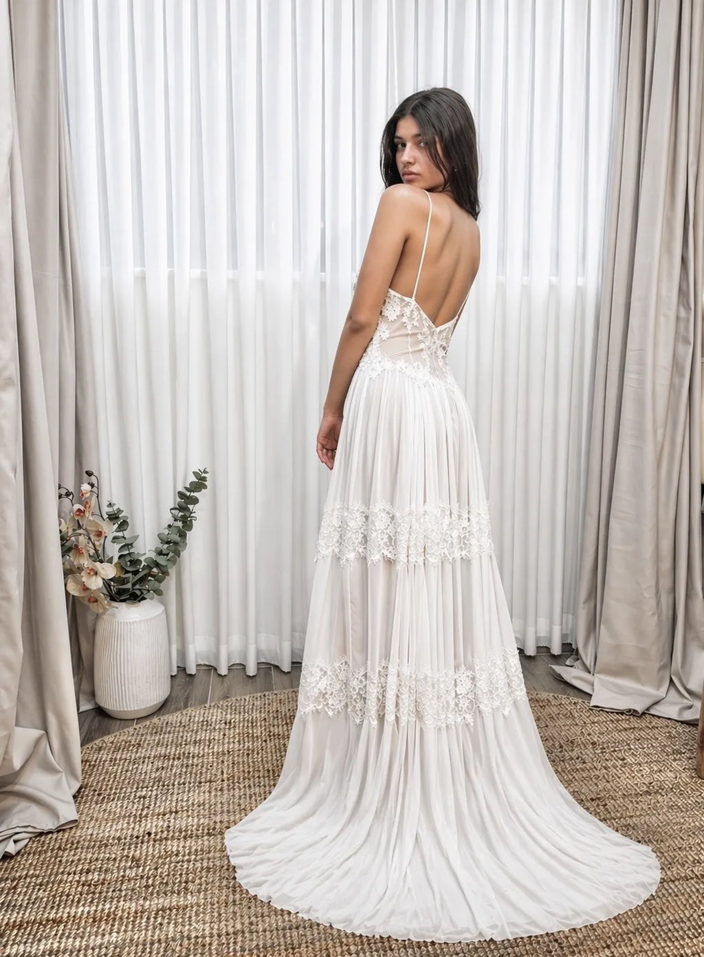 Back view of a boho lace wedding dress with a long flowing train