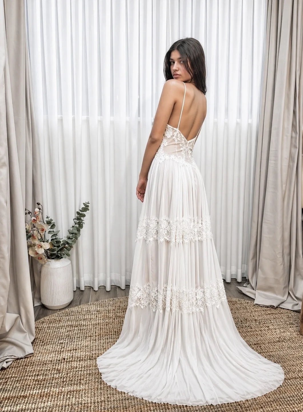 Back view of a boho lace wedding dress with a long flowing train