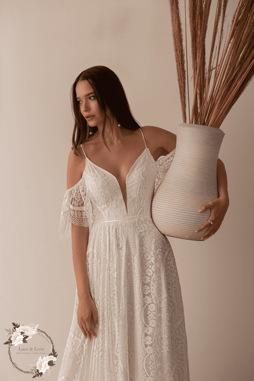 Bride wearing a boho lace wedding dress with drop sleeves