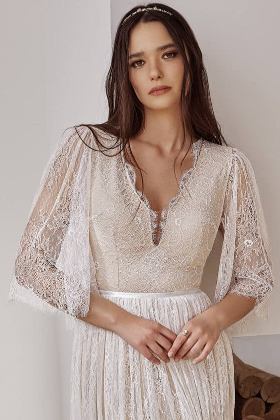 Bride wearing a boho lace wedding dress with long sleeves and deep V-neck