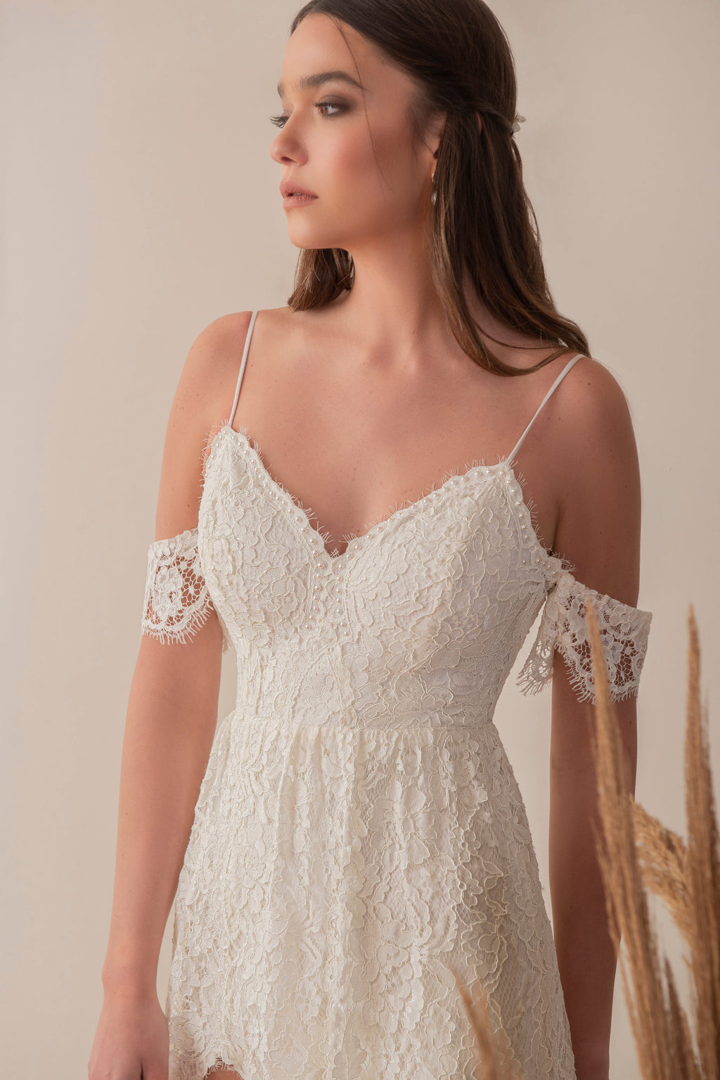 Side view of a boho lace wedding dress with delicate straps and sleeve detail