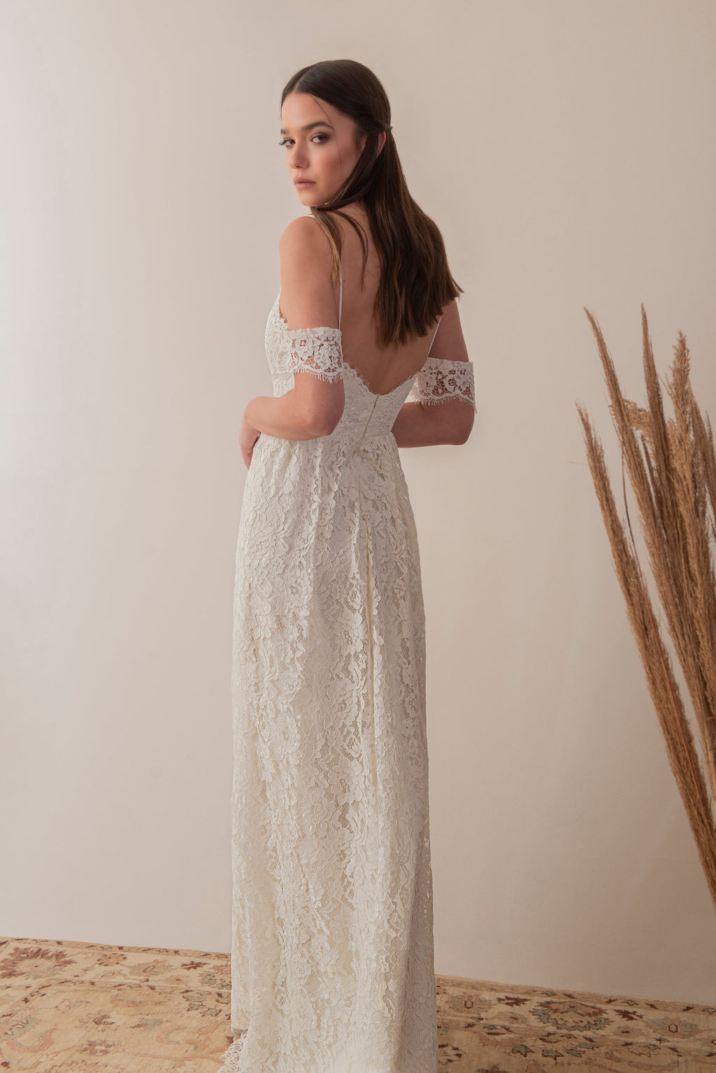 Side back view of a boho lace bridal gown with open back