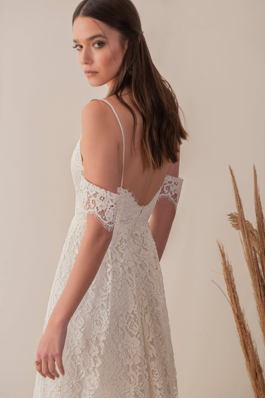 Side view of a boho lace wedding dress with delicate straps and sleeve detail