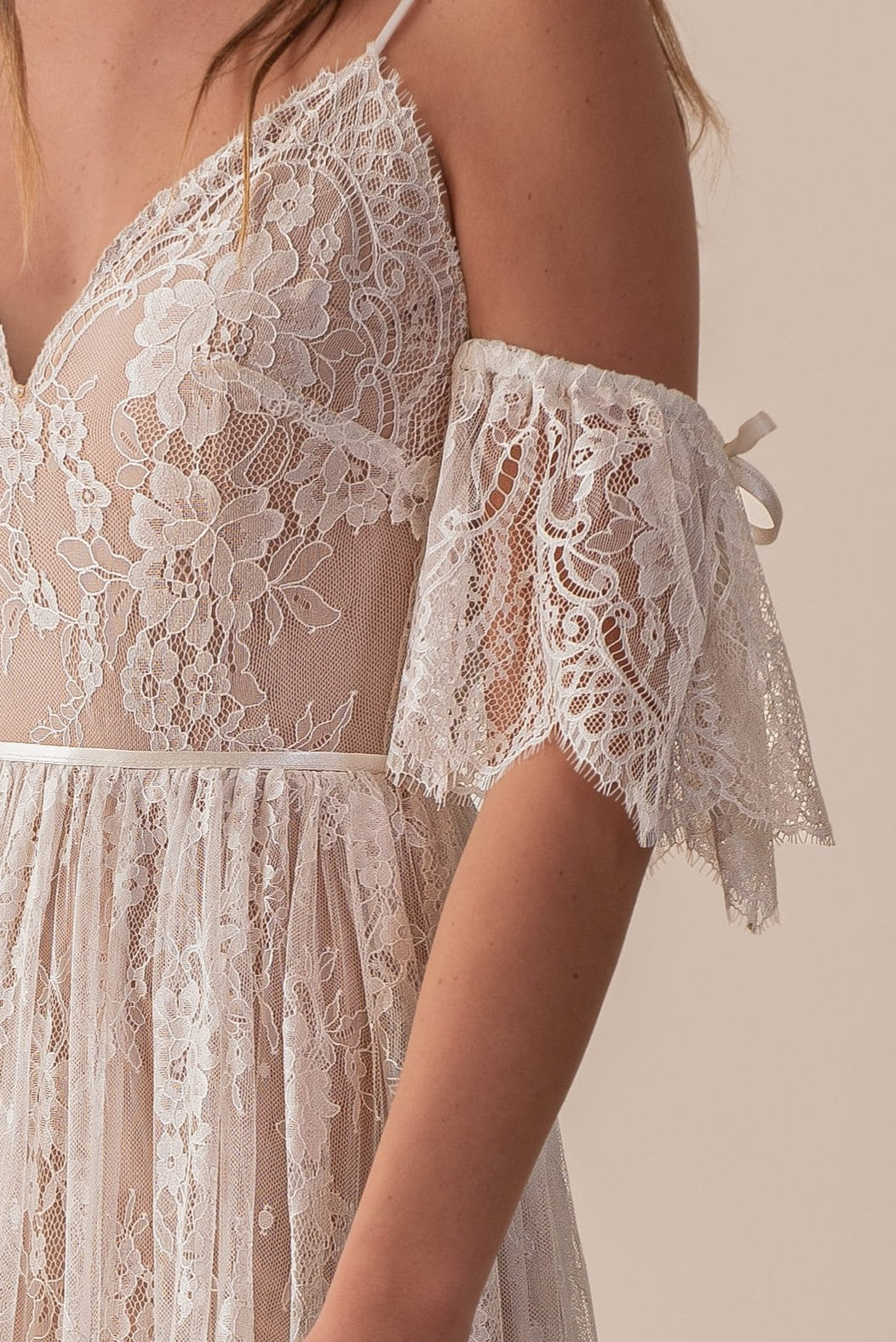 Close-up of lace wedding dress with off-shoulder sleeve detail