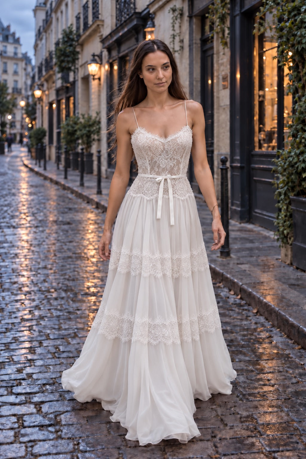 Luna Gown, sweetheart lace bodice with spaghetti straps, bow belt and tiered chiffon skirt with lace bands, bride on a cobblestone street