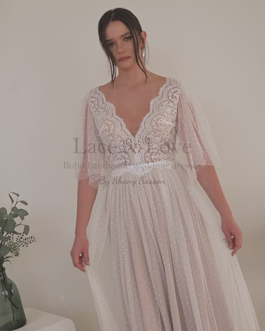 Bride in a V-neck boho lace wedding dress, seated, handmade by Shany Sasson