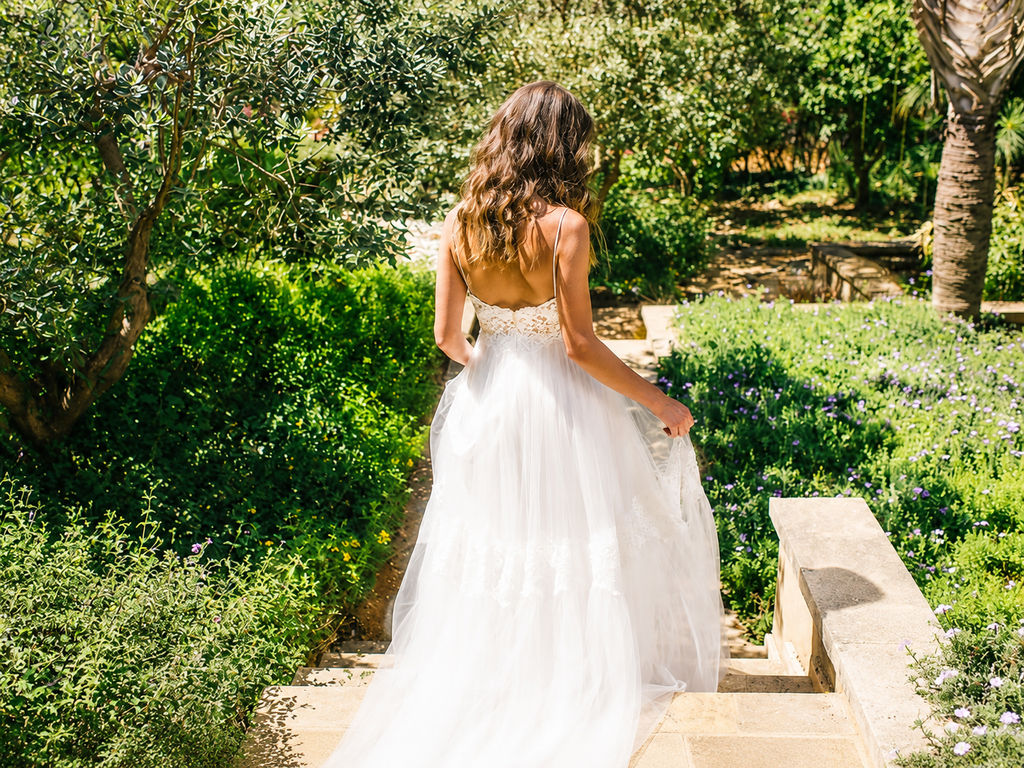 Back view of a real bride wearing a boho lace wedding dress in a garden