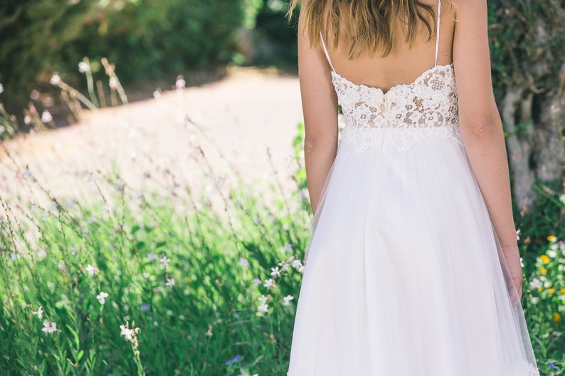 Back view of a real bride wearing a boho wedding dress in a garden