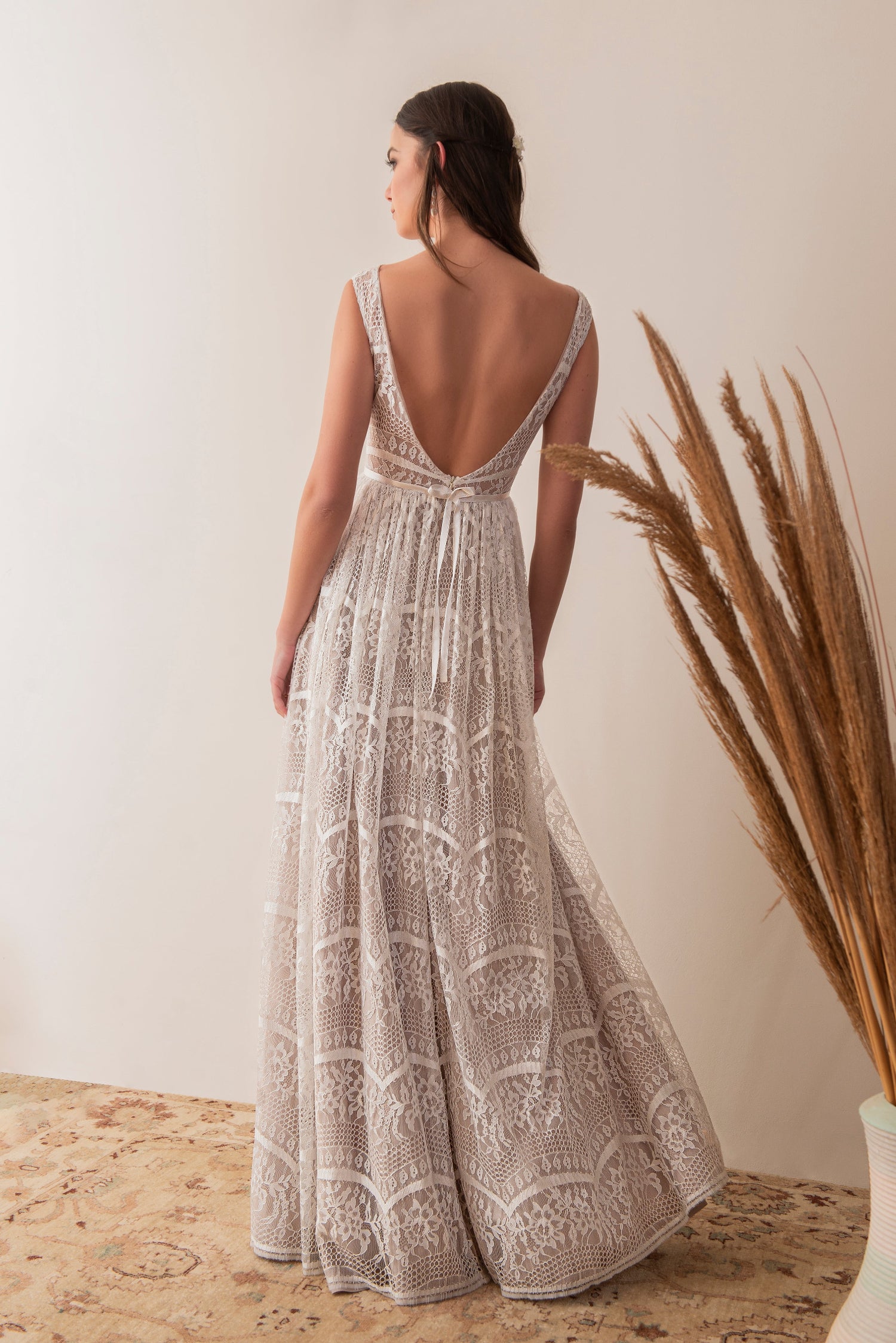 Side back view of a boho lace bridal gown with flowing skirt
